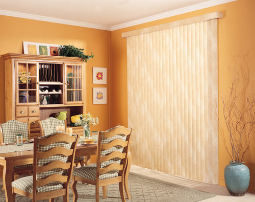 Cream vinyl vertical blinds drawn across a sliding patio door in a dining room